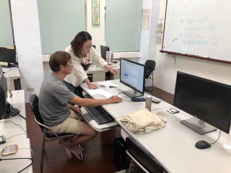 講師在學員螢幕前以手指引導使用程式。