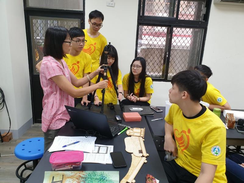 明志科大的資訊服務志工們，立起腳架放上照相機準備拍攝照片。