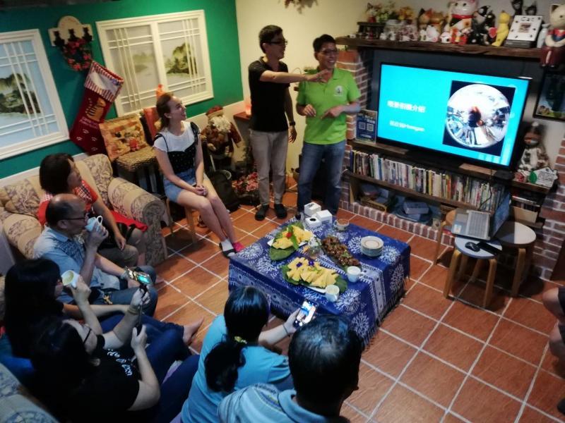 在一個四方的小房間中，學員們坐在沙發上，講師站在電視螢幕前將投影片撥出，開始了環景相機的課程。