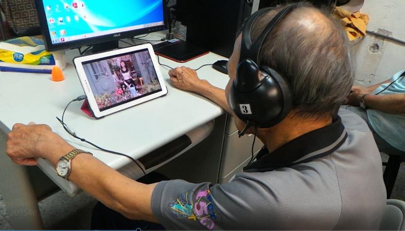 看看李金盛阿公陶醉在平板電腦歌唱當中