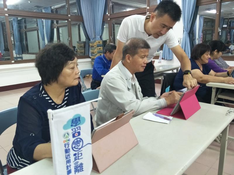學員看著老師示範怎麼操作平板