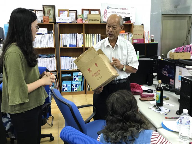 學員手拿紙盒與講師討論如何設計美化。