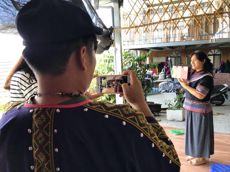 學員使用手機拍攝手拿產品的老闆娘。