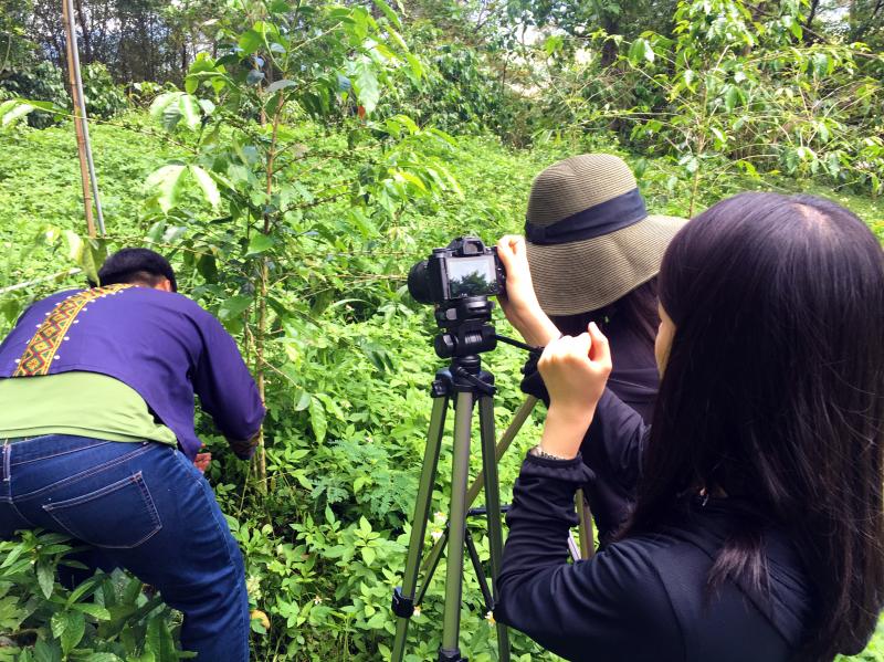 學員使用相機拍攝正在工作中的小農。