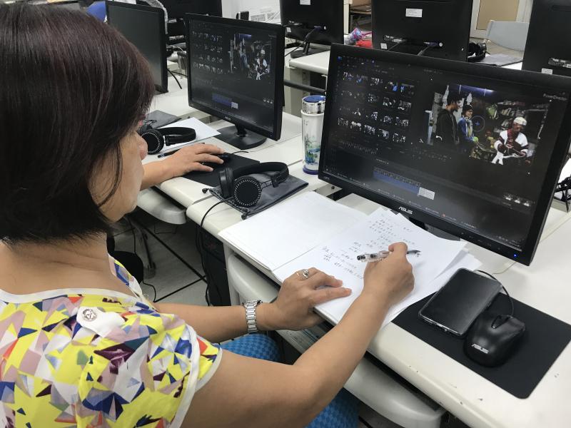 學員正在認真抄寫筆記，記下新聞稿撰寫流程與影片腳本編排的注意事項。