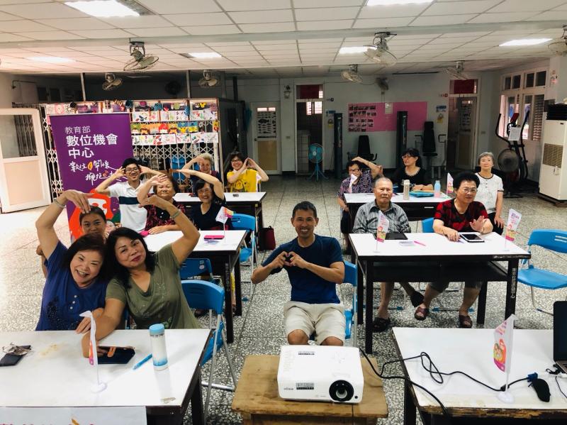 課程結束後,學員與講師坐在一起雙手比愛心合照。