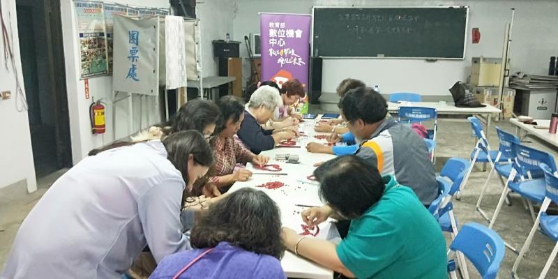 大家都低著頭用相思豆來黏圖片外觀