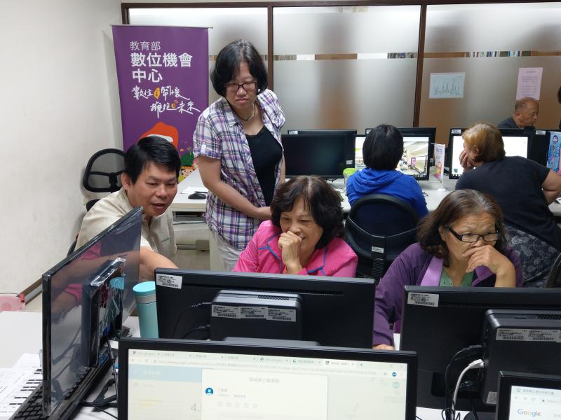 學員將剛才講師教受的內容做彼此交流，左方的學員在螢幕前比劃，右方學員露出笑容，單手握拳置於自己面前。