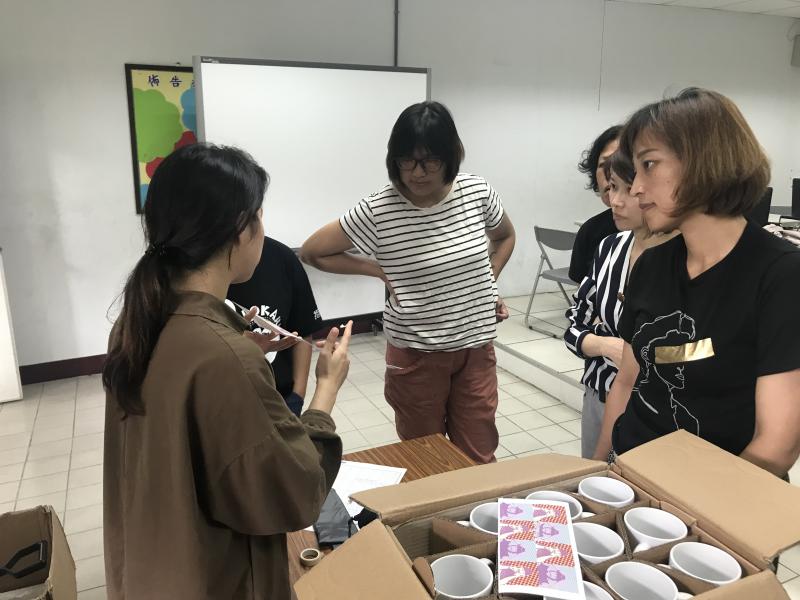 講師正在講解馬克杯熱轉印的注意事項，學員專注聆聽，等待機器熱機完成就可以進行製作。