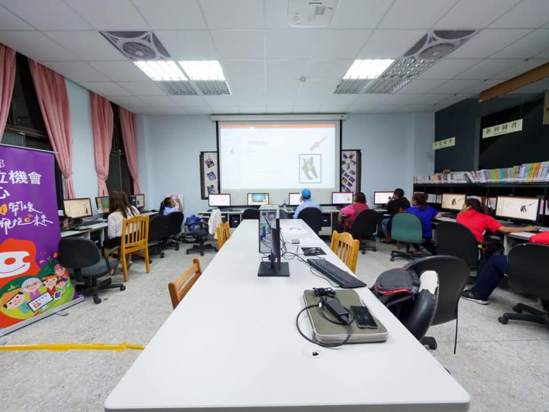 所有學員坐在自己的桌前，看著講師播放的投影片，介紹ppt的功能。