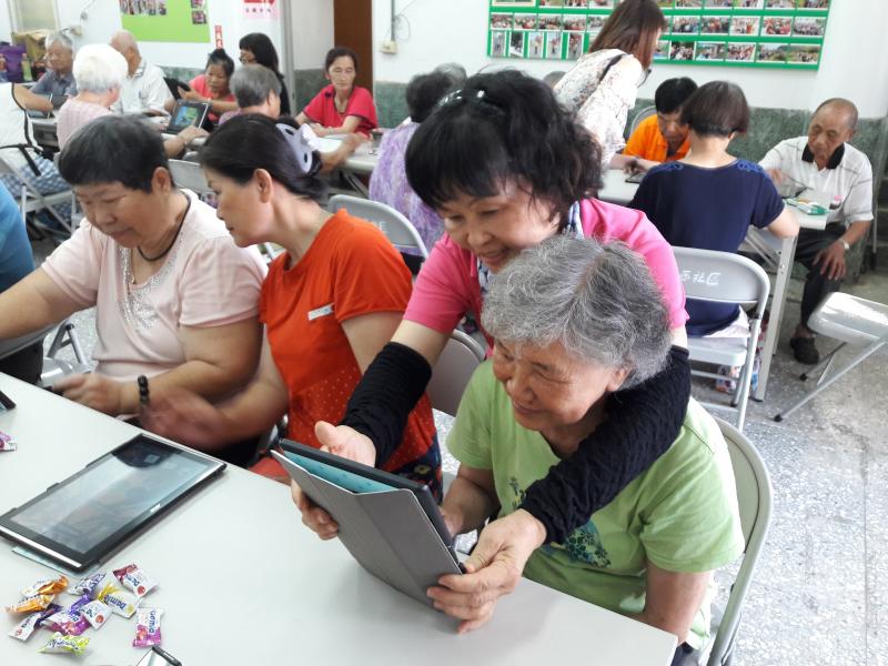 志工協助平板電腦操作使用