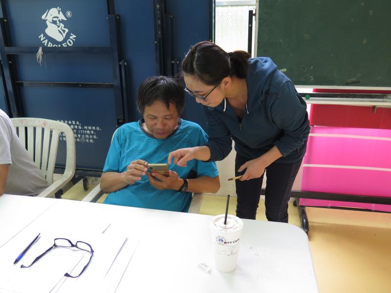 講師一旁指導學員如何應用導航來規劃旅遊路線。