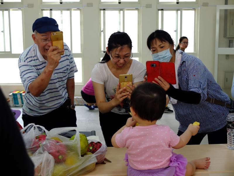 現成的小小模特，拿著水果開心吃的模樣，怎麼拍都好看