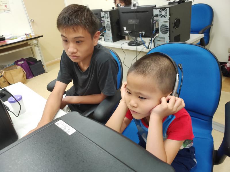 大哥哥協助旁邊的小弟弟