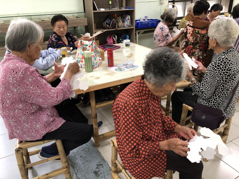 大家專注地動動腦將手中紙板順著線條摺出立體的存錢筒