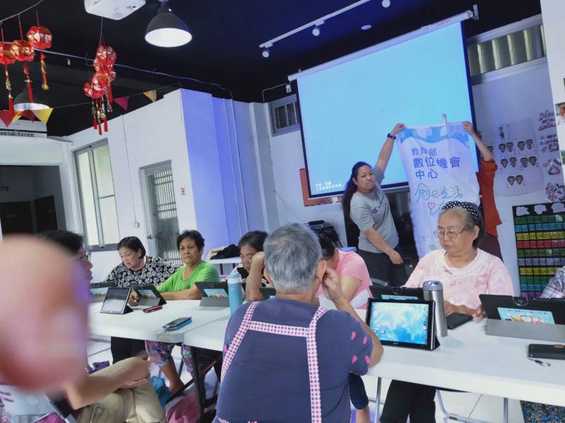 年長的學員們將平板立起，開始使用平板內的小遊戲，幫助熟悉平板電腦的操作。