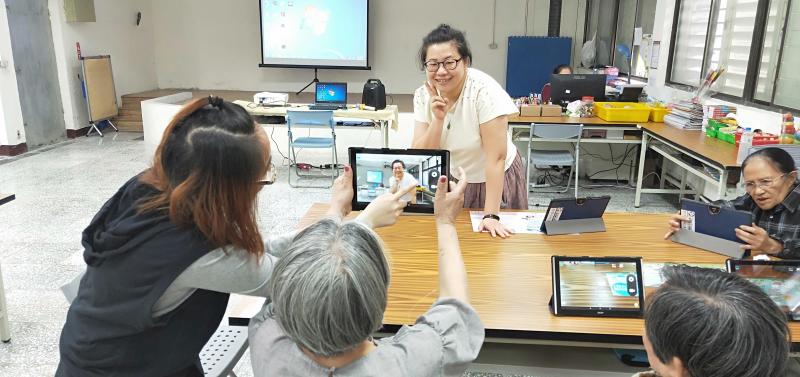 老師帶領大家操作平板，讓大家練習如何使用拍照功能。