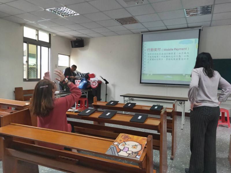 課堂間的休息時間，學員們站起來走動以提振精神，由一位學員則將雙手舉起。