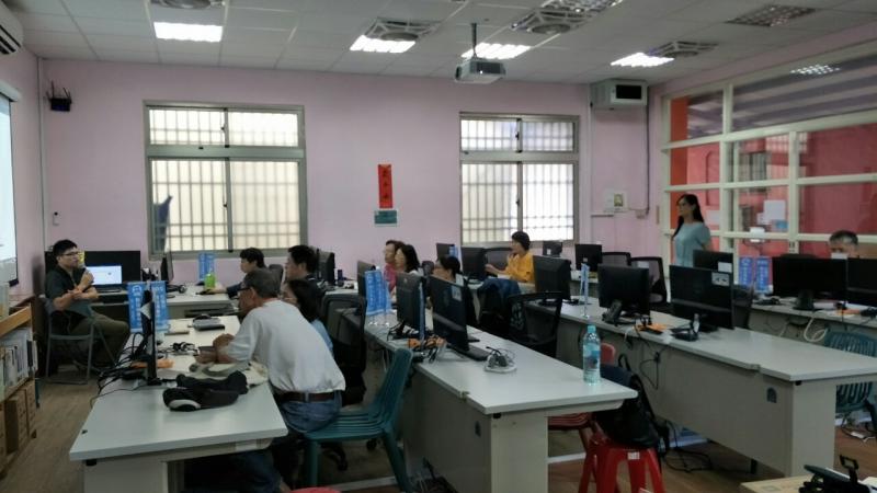 講師專注的坐在電腦前為學員們講授word的使用技巧，包含版面配置、文字段落。