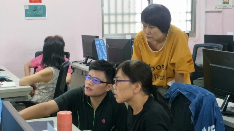 講師親自站在學員的旁邊，指導學員操作word插入圖片。