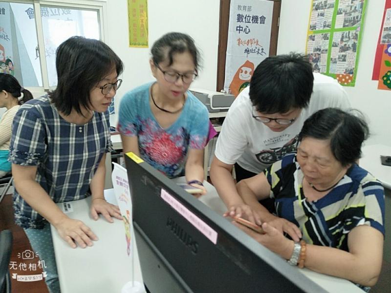 三位學員圍繞在一位較為年長的學員身旁，幫助解決她的問題。