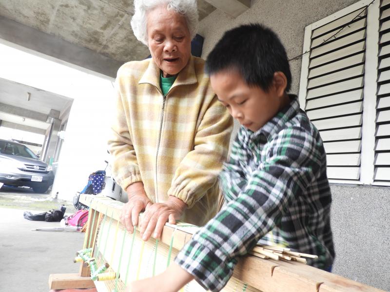 阿媽也和小朋友一起動手做原住民最原始的草蓆