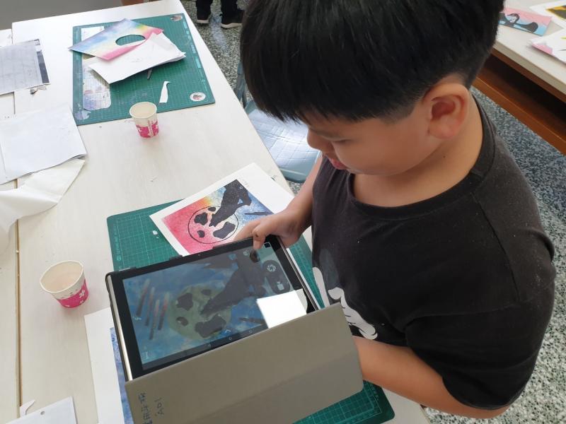 學員正在專注於選取圖片，將雙手放置於平板上。