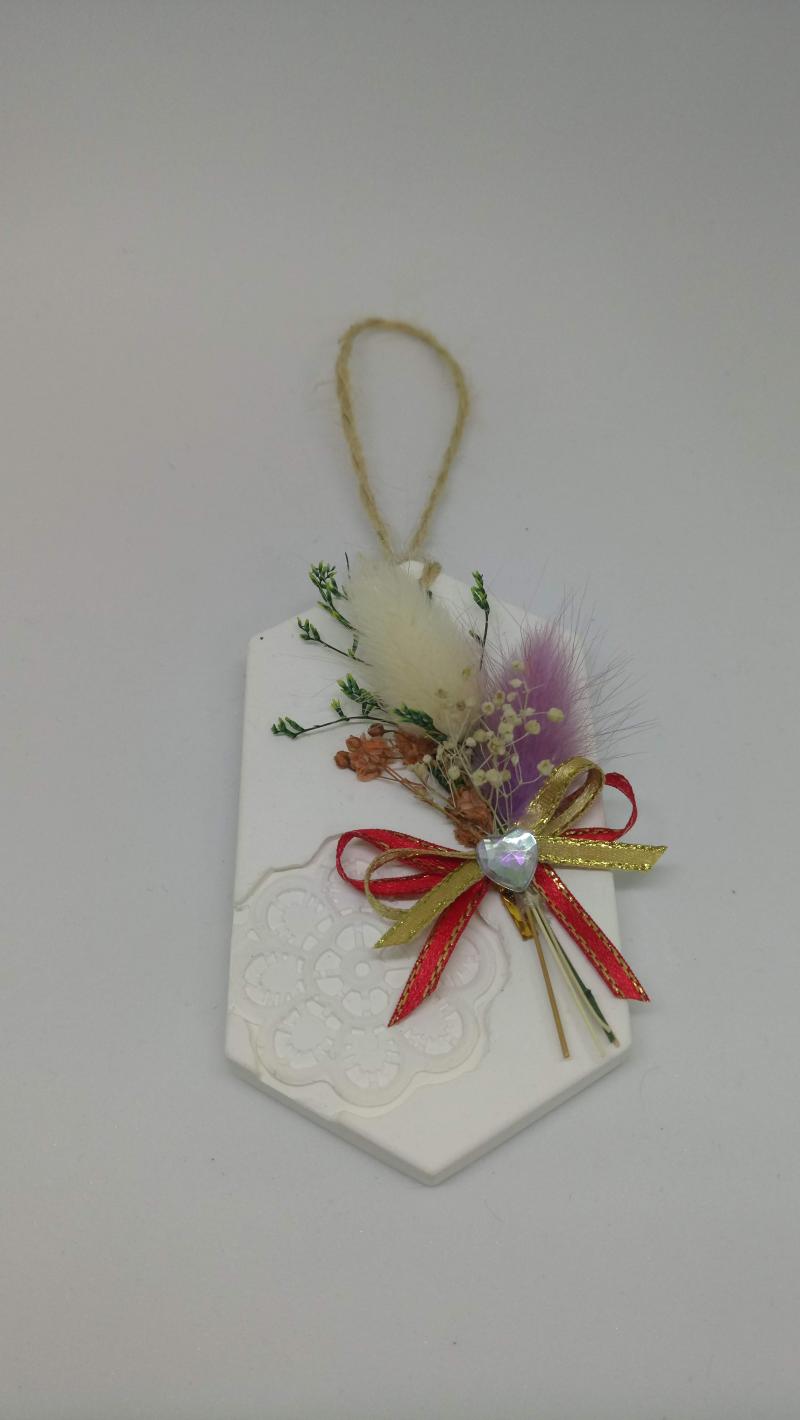 講師示範的3D灌模的石膏完成作品，六角形的白色牌子，綁上紅色蝴蝶結與乾燥花作為裝飾。