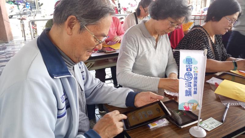 長輩學員認真的學習平板的操作。