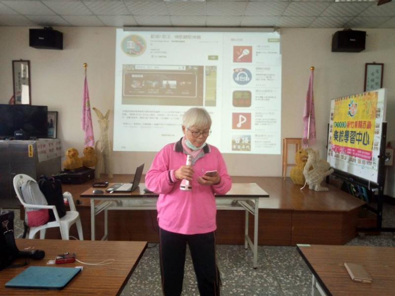 這是學員用著是她自己的手機接上老師藍芽麥克風唱歌