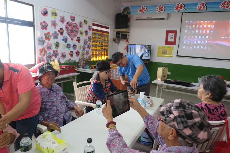 社區發展協會總幹事潘仲原先生與學員一同體驗平板電腦。