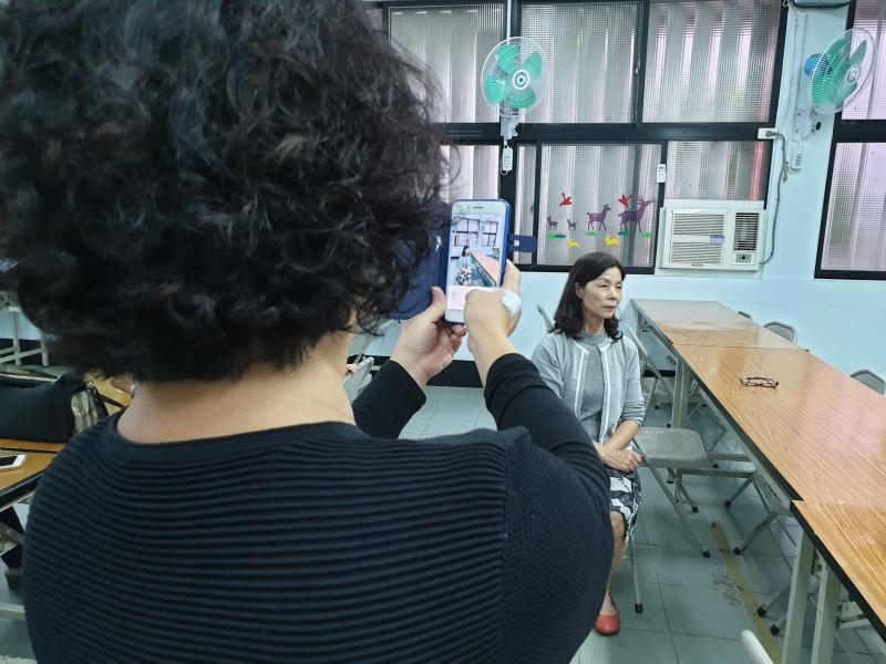 湖西村長夫人用手機為志工拍個人照