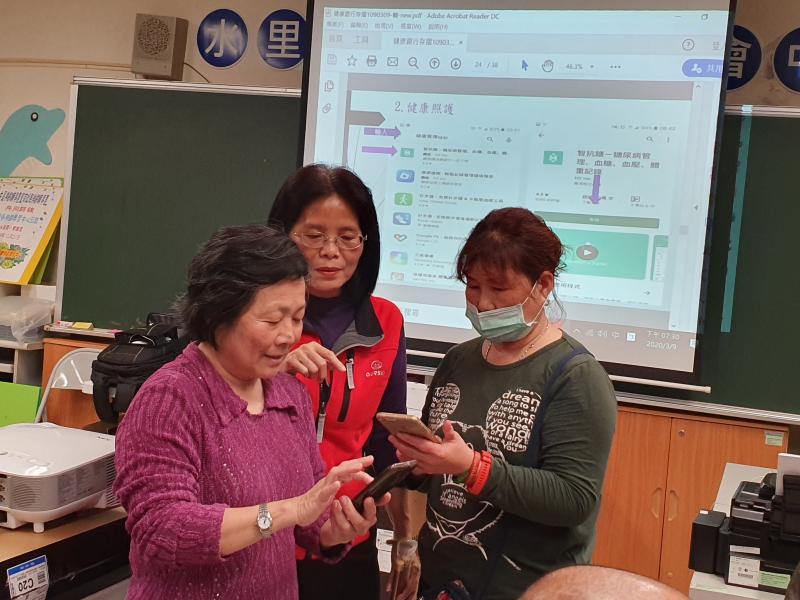 老師在旁協助學員手機操作上問題.