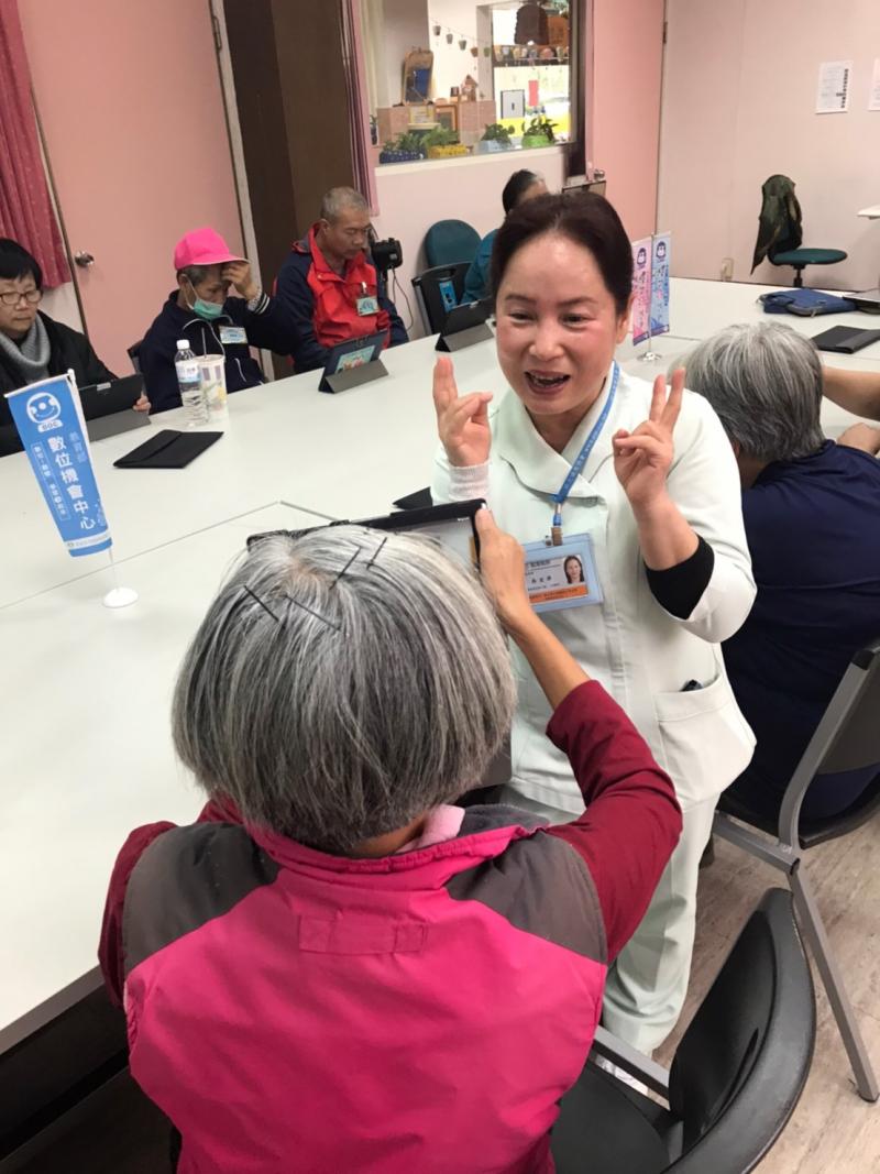 老師指導學員使用平板相機拍照,學員練習幫老師拍照!