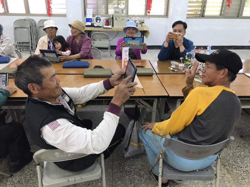 指導老師教導學員們使用平板相機,相互幫對方拍照~