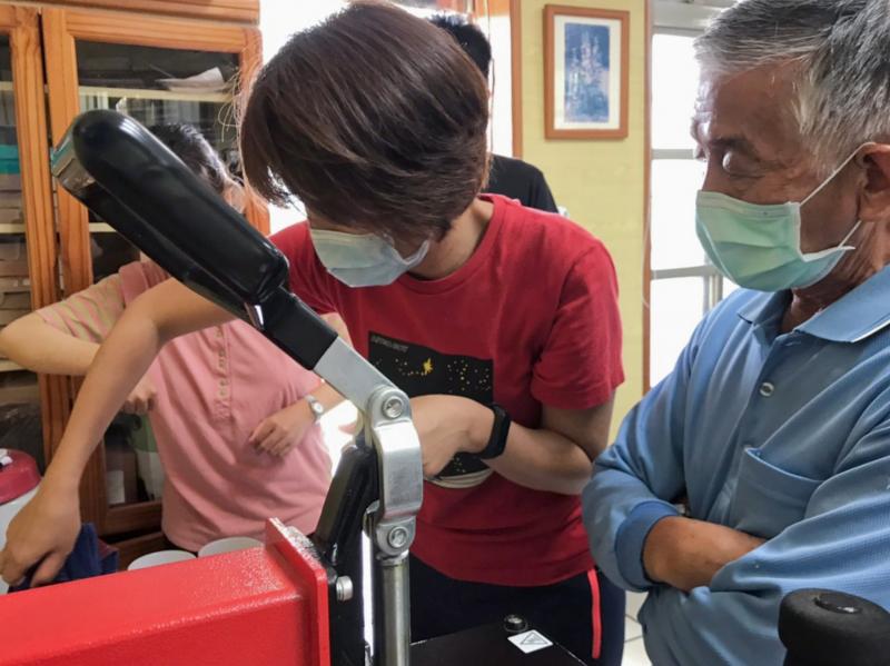 學員將馬克杯放入熱轉印機