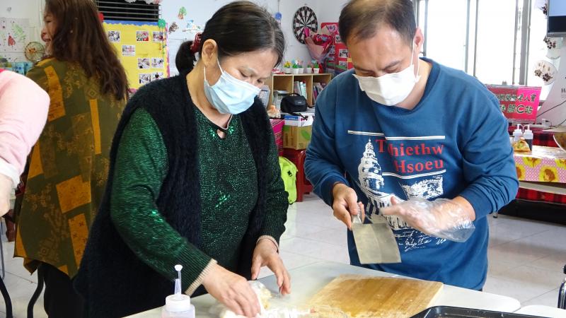 部落婦女帶著部落男人小心切刀。