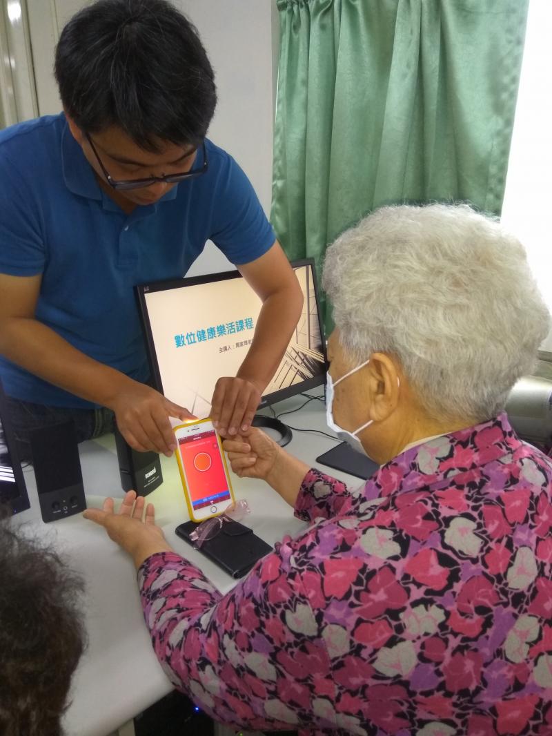 老師指導學員如何運用手機測量自己的心跳，了解自己的健康狀況。