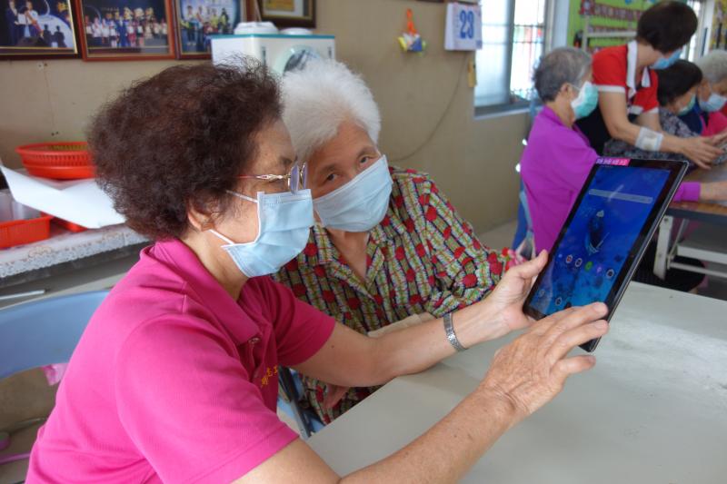 聽完老師教學後，學員們互相指導如何開啟網路看影片。