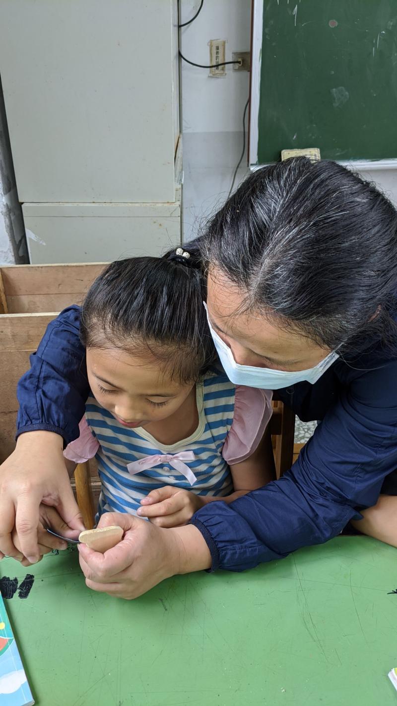 南澳樂齡學習中心的阿姨手把手教南澳國小的學童操作雷射雕刻前置作業