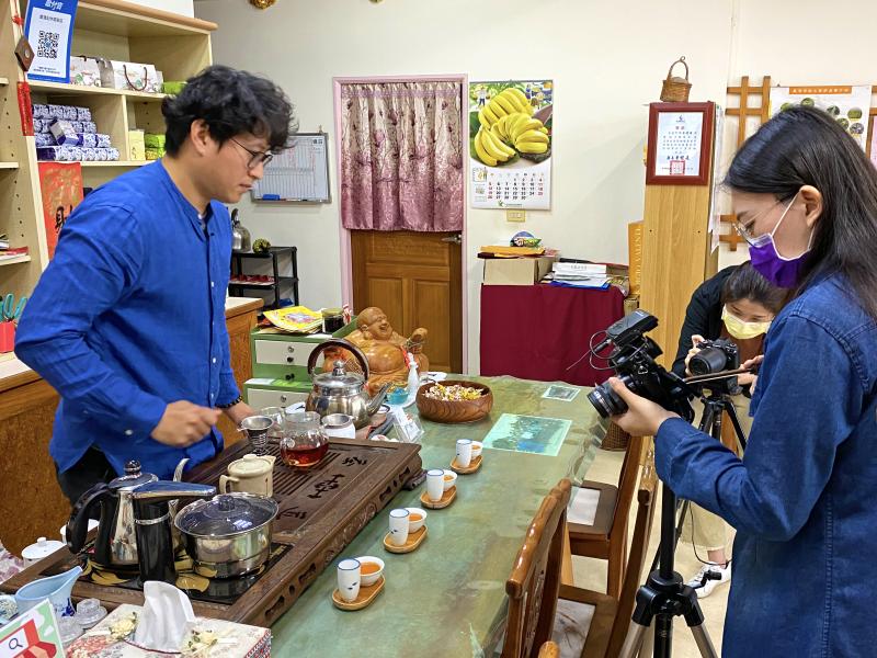 學員練習使用腳架及相機，老闆在一旁準備。