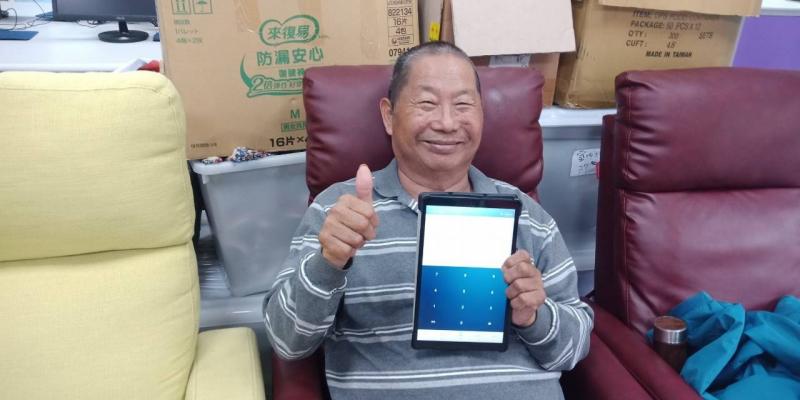 很開心的拿著平板做對發票的學員。