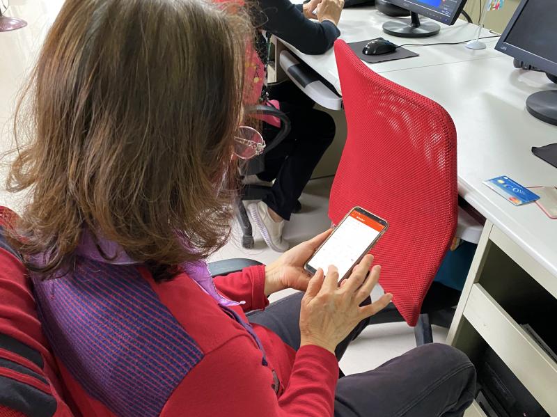 學員手拿智慧型手機，操作下載行動支付APP