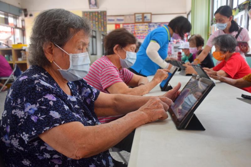 長者認真操作示範的APP益智遊戲。