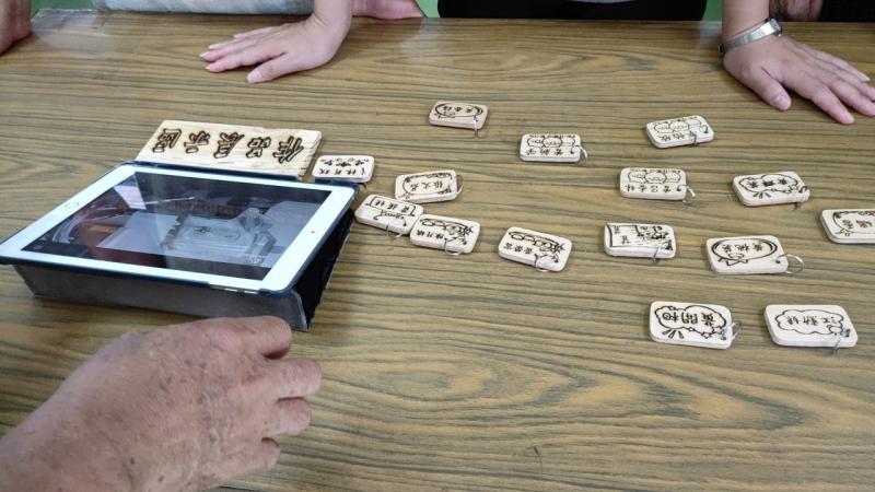 學員跟著範例圖所描繪的圖樣及簽名，做成鑰匙圈吊飾。