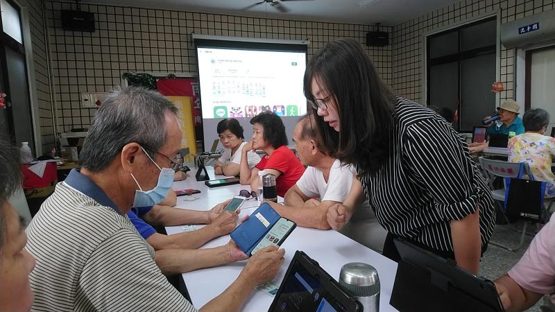 田老師示範說明下載健康存摺APP，讓學員用自己手機操作下載，他一一為不太會學員指導如何下載介面，建立學員學習信心。