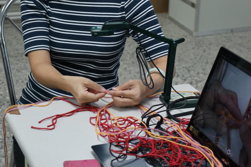 老師透過實物投影機手部動作教學