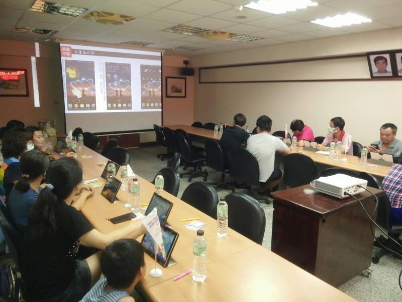 學員很認真聽老師說明怎麼使用平板和設定APP聽歌唱歌