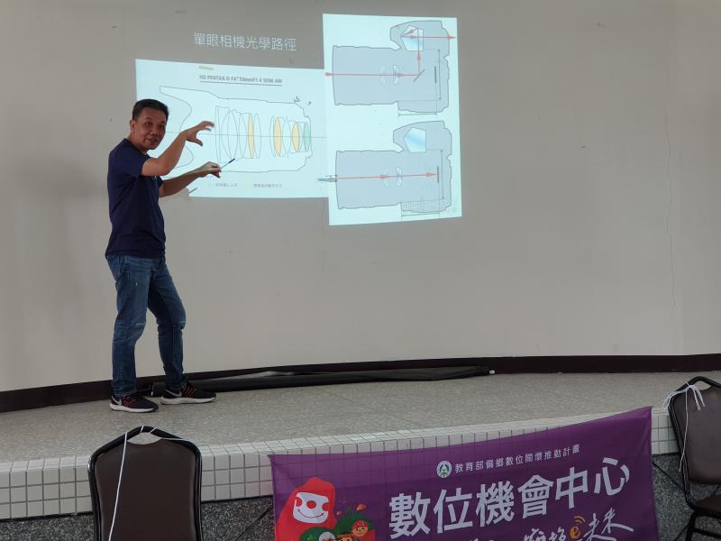 男老師在講台上解說如何使用相機