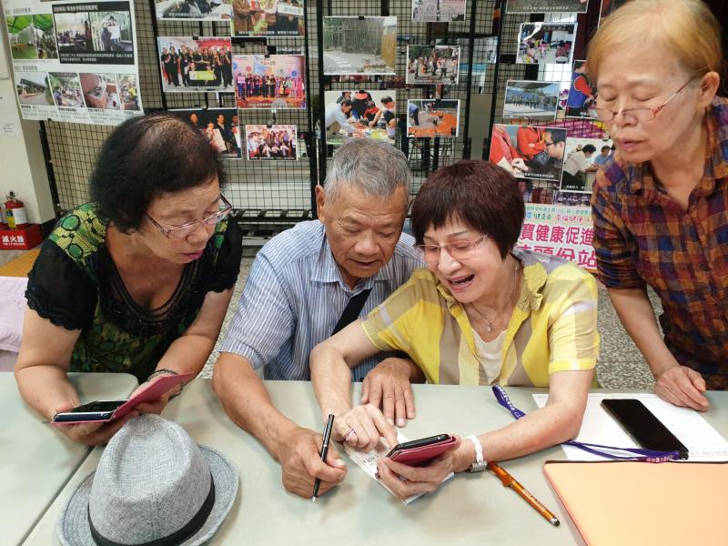 一群人在學習怎麼點手機